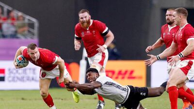 Wales' Gareth Davies looks to break the tackle of a Fijian defender during the Rugby World Cup Pool D game at Oita Stadium between Wales and Fiji in Oita, Japan. AP