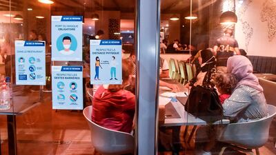 Notices are plastered at the entrance of a restaurant in Algiers, reminding customers to respect safety measures against the novel coronavirus after lockdown restrictions were eased by the authorities. AFP