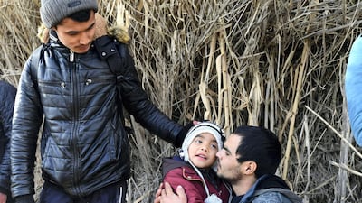 A man hugs a child upon their arrival at the village of Skala Sikaminias, on the Greek island of Lesbos, after crossing the Aegean sea from Turkey with other migrants. AP