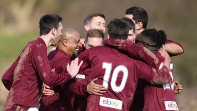 Roberto Carlos celebrates with Bull in the Barne United players after scoring a penalty. AFP