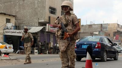 Loyalist forces stand guard on a main road in Al Mansoura district after pushing Al Qaeda out of parts of the southern city on March 30, 2016. Saleh Al Obeidi/AFP
