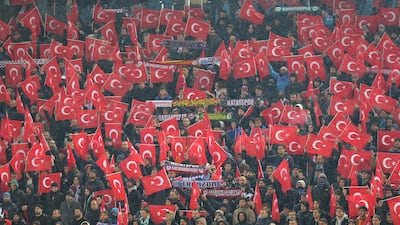 Trabzonspor supporters wave Turkish flags in support for the earthquake victims. EPA