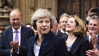 Britain's Theresa May is applauded by Conservative Party members of parliament outside the Houses of Parliament in London (AP Photo/Max Nash)