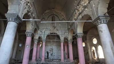A Christian fighter from Hashed Al Shaabi (Popular Moblisation units) walks inside a heavily damaged Syriac Orthodox church named Al Tahera in the old city of Mosul on January 9, 2018. AFP