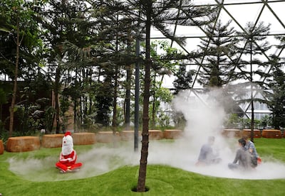 A man in a chicken costume sits in mist inside Jewel Changi Airport. Reuters