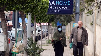 A woman wearing a face masks walks past Rafik Hariri University Hospital in Beirut, Lebanon. Bloomberg