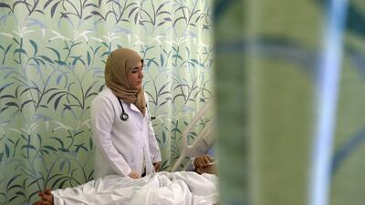 Hessa Ali, an Emirati trainee doctor, talks to a patient at Sheikh Khalifa Hospital in Ajman. Pawan Singh / The National