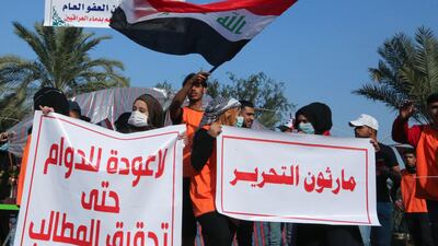 Iraqi students carry banners as they march during ongoing anti-government demonstrations in the capital Baghdad's Tahrir square. AFP