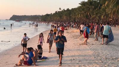 Visitors gather along the beach on Boracay. AP Photo