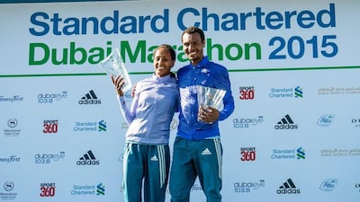 Ethiopian women's Dubai Marathon winner Aselefech Mergia, left, and Ethiopian men's winner Lemi Berhanu Hayle, right, pose with their trophies after the 2015 Dubai Marathon on Friday. Stephen Hindley / AP
