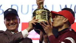 Jose Ortiz, right, celebrates with the Dubai World Cup trophy after riding Magnitude to victory. Reuters