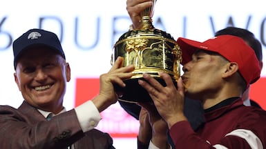 Jose Ortiz, right, celebrates with the Dubai World Cup trophy after riding Magnitude to victory. Reuters