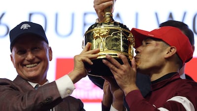Jose Ortiz, right, celebrates with the Dubai World Cup trophy after riding Magnitude to victory. Reuters