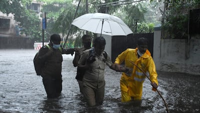 An Indian policeman helps out on a flooded street in Mumbai after a bus broke down in heavy rain carried by cyclone Tauktae. EPA