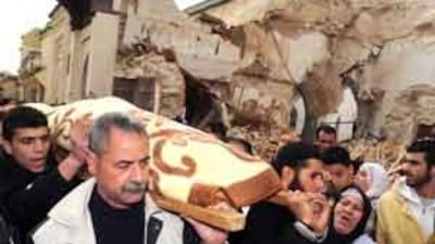 Mourners walk past the collapsed historic minaret in Meknes's old quarter.
