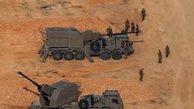Israeli soldiers next to artillery vehicles near the Israel-Lebanon border. Reuters