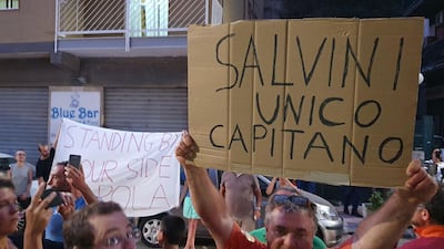 A man holds a placard reading "Salvini only captain" outside the building where Sea-Watch 3 captain Carola Rackete has been staying under house arrest, on July 2, 2019 in Agrigento, Sicily. AFP