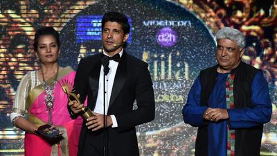 Winner for Best Performance in a Leading Role Bollywood actor Farhan Akhtar, flanked by Shaban Azmi and Indian poet and lyricist Javed Akhtar, accepts his trophy on stage. Jewel Samad / AFP