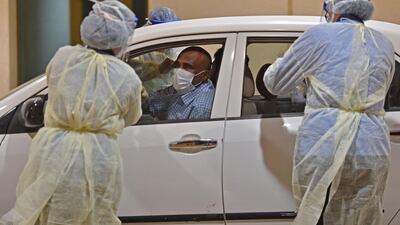 Health workers perform a nose swab test during a drive through coronavirus test campaign held in Diriyah hospital in Riyadh. AFP