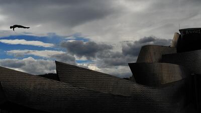An athlete performs during the RedBull Cliff Diving competition final in Bilbao, Spain. Pictured in the background is the Guggenheim Museum Bilbao. Isaeva Daria / sovsport.ru