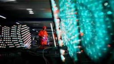 A worker examines the circuit boards of solar traffic signal lamps in China.