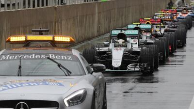 Lewis Hamilton leads other cars in the pit area behind the safety car during a pause in racing due to heavy rainfall. Paulo Whitaker / Reuters