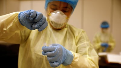 A healthcare worker takes a nose swab for an attendee's Covid-19 antigen rapid test before a conference held by the Institute of Policy Studies at Marina Bay Sands Convention Centre in Singapore. Reuters