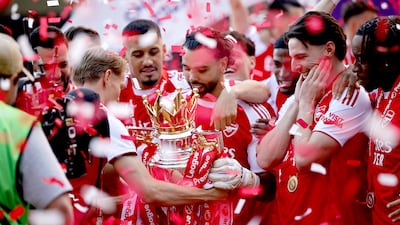 Arsenal captain Martin Odegaard hands goalkeeper David Raya the Premier League trophy. EPA