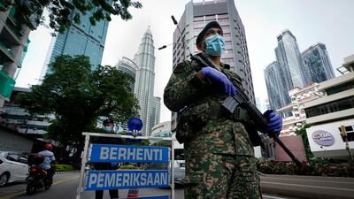 An armed soldier stands guard at a roadblock on the first day of a movement control order in downtown Kuala Lumpur, Malaysia. AP Photo