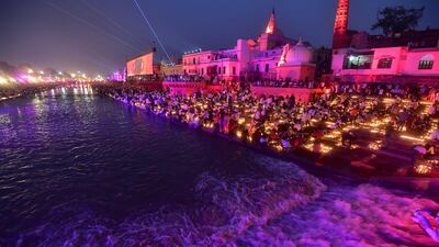 Devotees light earthen lamps on the banks of the Saryu river in Ayodhya on Saturday. AFP