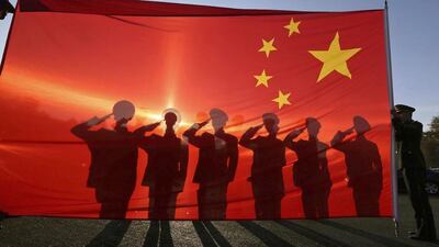 Retired paramilitary policemen, who conduct the daily national flag raising and lowering ceremony on Tiananmen Square, salute to a Chinese national flag during a farewell ceremony in Beijing. Reuters