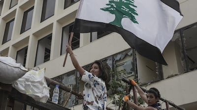 An anti-government protester holds a Lebanese flag which has had the usual red stripes replaced with black as a sign of mourning, during a demonstration on September 1, 2020 in Beirut. Getty