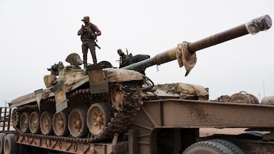 A Syrian soldier stands guard over a tank following the withdrawal of the SDF from Maskanah, near Aleppo, on Saturday. Reuters