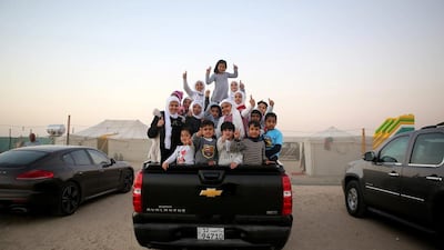 Kuwaiti children pose for a picture outside a winter camp close to the border with Saudi Arabia, in al-Julaia, around 70 kilometres (45 miles) from the capital Kuwait City. Yasser Al-Zayyat / AFP