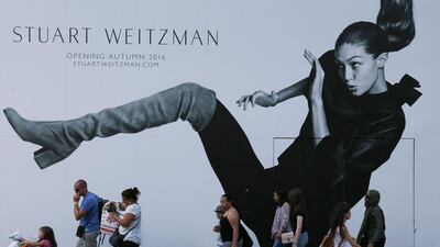 Pedestrians in central London walk past a billboard featuring the model Gigi Hadid (AFP / DANIEL LEAL-OLIVAS)