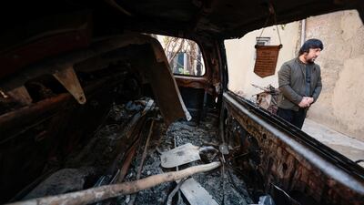 Ajmal Ahmadi stands beside a car which was damaged during a US drone strike that killed 10 civilians, including seven children, as he speaks with journalists at the house's courtyard in Kabul, Afghanistan, on November 7, 2021. Reuters