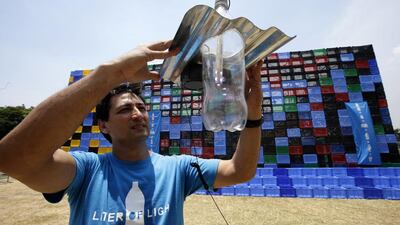 Filipino entrepreneur and environment activist Illac Diaz demonstrates his solar-powered bottle bulb. Mr Diaz’s sustainable energy project has provided light to thousands of homes in the Philippines and elsewhere around the world since 2010. Dennis M Sabangan / EPA