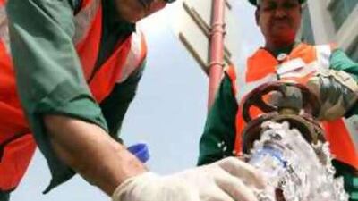 Workers take water samples for testing from a fire hydrant in Abu Dhabi.