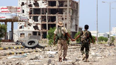 Members of Houthi militia pass a destroyed building during the deployment of observers on cross-lines in Hodeidah, Yemen, 19 October 2019. EPA