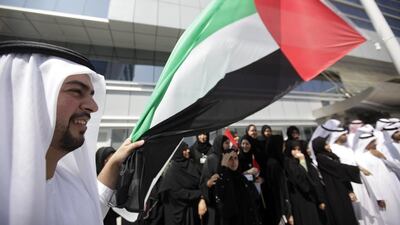 Khadem Al Hameli with the General Secretariat of Executive Council participates in a flag-raising ceremony to mark flag day. Sammy Dallal / The National