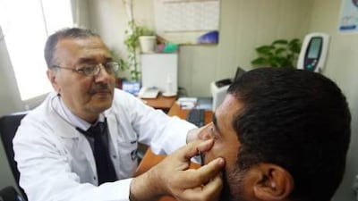 Dr Muneer Hamad attends to a patient at the Dubai Municipality's public health services department.