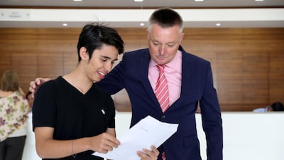 Juan Felipe Salazar shows his GCSE results to John Pugh , assistant head teacher and drama teacher at Kings School in Al Barsha in Dubai. Pawan Singh / The National