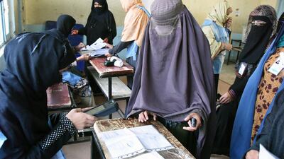 An Afghan Independent Election Commission (IEC) official scans a voter with a biometric device at a polling centre for the country's legislative election in Kandahar province on October 27,2018. AFP