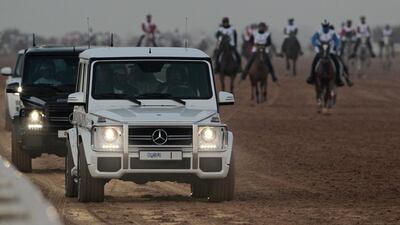 Sheikh Mohammed bin Rashid drives his car alongside the track during the race.