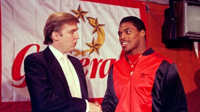 Former US president Donald Trump shakes hands with Herschel Walker after the US football player signed a four-year contract with the New Jersey Generals USFL football team. AP