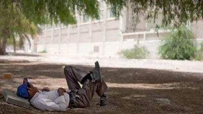 Darsaking, a carpenter from Bangladesh, takes his midday break near the intersection of Defence Road and Khaleej Al Arabi in the capital.