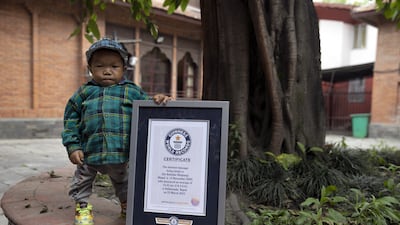 Dor Bahadur Khapangi, 18, poses with his Guinness World Records certificate after he was acknowledged as the world's shortest person, in Kathmandu, Nepal. He is 73.43 centimetres tall. EPA