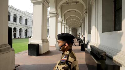 A security officer wears a protective mask as he stand guard at empty Indian Museum in Kolkata. EPA