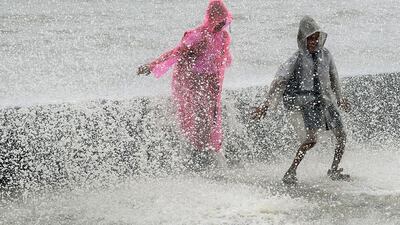 Indian youths play in breaking waves on the seafront during high tide in Mumbai. Punit Paranjpe / Reuters