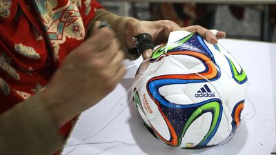 An employee hand-stitches the panels of an Adidas AG "Brazuca Replica Glider" football on the production line at the Forward Sports Ltd factory in Sialkot, Punjab. Asad Zaidi / Bloomberg